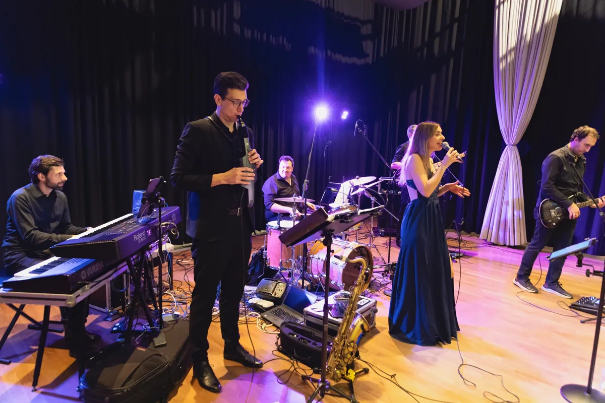 Die Hochzeitsband Iris' Coffeeshop live auf der Bühne mit Piano, Saxophon, Schlagzeug, Gesang und Gitarre